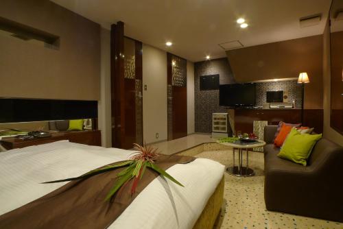 三浦市にあるホテルマーメイド（大人専用）のベッドとリビングルームが備わるホテルルームです。