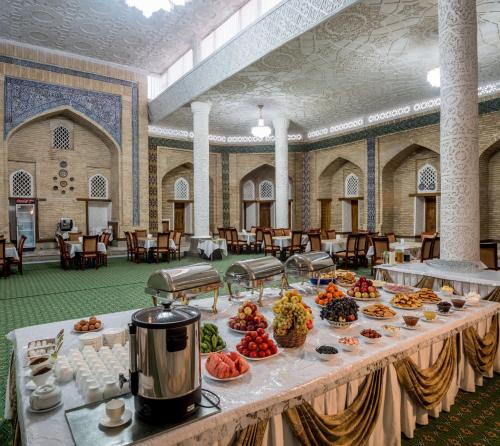 a buffet of food on a table in a room at Orient Star Khiva Hotel- Madrasah Muhammad Aminkhan 1855 in Khiva