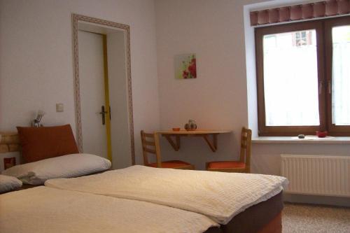 a room with two beds and a table and a window at Alte Posthalterei in Stolberg i. Harz