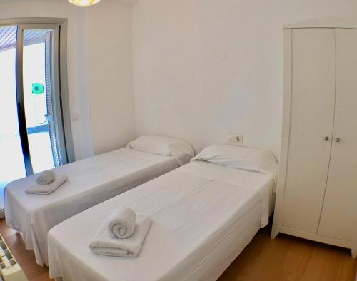 サロウにあるApartamento Playa Capellans - Gran terrazaの白い部屋のベッド2台(タオル付)