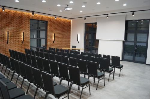 a conference room with black chairs and a projection screen at Ośrodek Turystyczny Warzenko in Warzenko