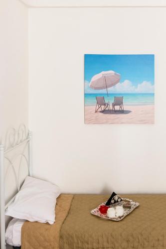 a bedroom with a bed and an umbrella on the beach at La Casa del Barocco in Noto