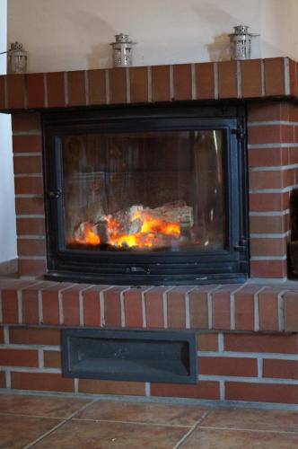 a brick fireplace with a fire in it at Ośrodek Turystyczny Warzenko in Warzenko