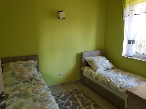 ルビャトボにあるDomki nad morzem Cyranowkaの緑の部屋(ベッド2台、窓付)