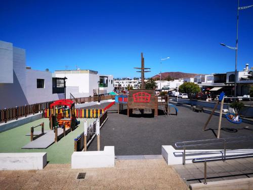 a playground in a parking lot with a playground at Apartamento Anaca in Playa Blanca
