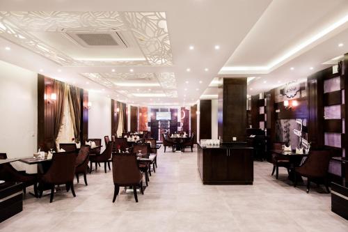a restaurant with tables and chairs in a room at Al Muhaidb Residence Al Ahsa in Al Ahsa