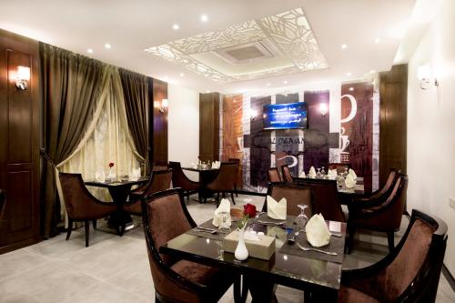a dining room with tables and chairs and a television at Al Muhaidb Residence Al Ahsa in Al Ahsa