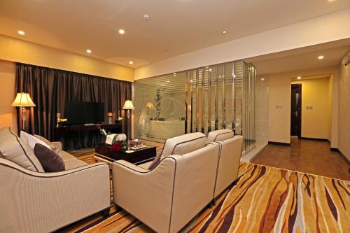 a living room with white chairs and a television at Al Muhaidb Residence Al Ahsa in Al Ahsa