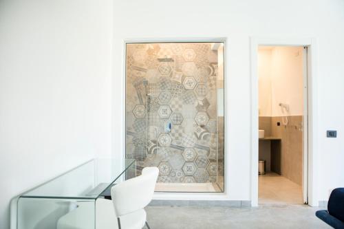 a wall mural in a living room with a white chair at Villa Landolina in Noto