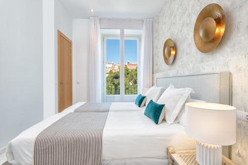 a white bedroom with a large bed and a window at iloftmalaga Premium Alameda Principal in Málaga