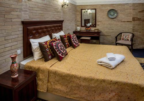 a bedroom with a large bed with pillows on it at Orient Star Khiva Hotel- Madrasah Muhammad Aminkhan 1855 in Khiva