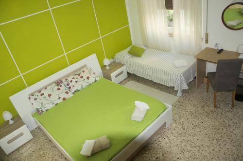 a green room with a bed and a table at B&B Myrta Maria in Cagliari