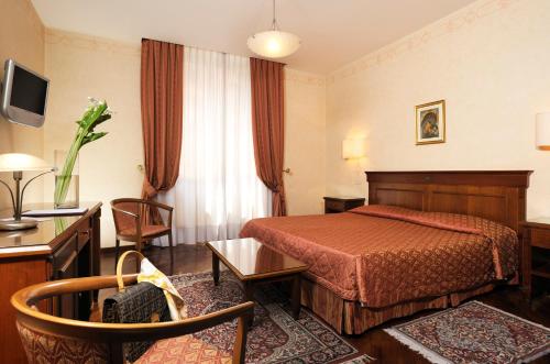 pokój hotelowy z łóżkiem, stołem i krzesłami w obiekcie Hotel Torino w Rzymie