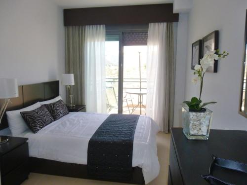 1 dormitorio con 1 cama grande y balcón en Apartamento con piscina, en Garrucha