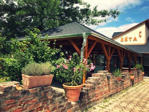 a building with potted plants on a brick wall at Hotel Zéta in Lenti