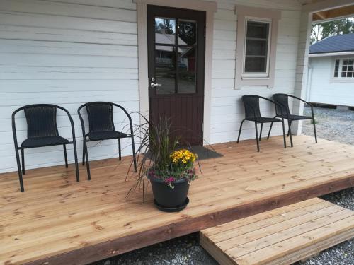 a wooden deck with three chairs on a house at Tohninmäen Talo in Töysä