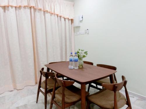 - une table avec 2 bouteilles d'eau et 2 chaises dans l'établissement Taiping Cozy Homestay II, à Taiping