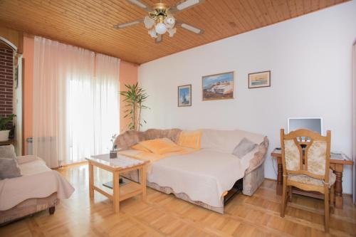 a living room with a couch and a table at Apartmani Branko Lemac in Brodarica