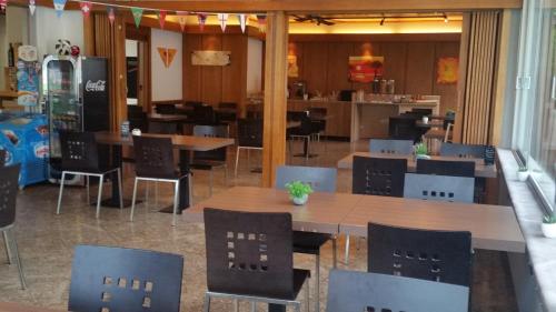 un restaurante con mesas y sillas en una habitación en Motel des Sports Martigny, en Martigny-Ville