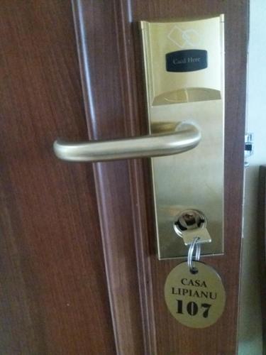 a door with a lock on it with a sign on it at Casa Lipianu in Târgu Jiu