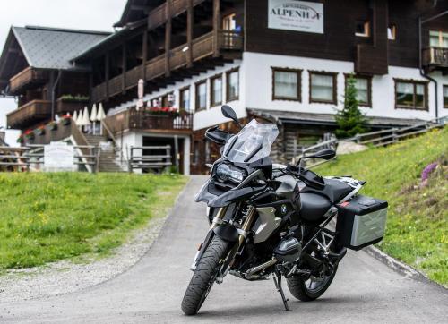 a motorcycle parked on a road in front of a building at Sattleggers Alpenhof & Feriensternwarte in Berg im Drautal