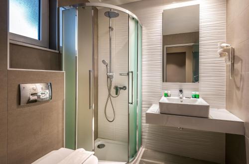 a bathroom with a shower and a sink at Sunday Hotel in Ialyssos