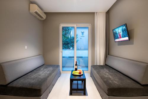 a room with two beds and a table with a bottle of beer at Sunday Hotel in Ialyssos