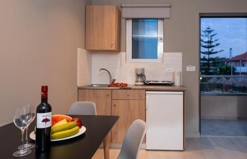 a kitchen with a table with a bottle of wine at Sunday Hotel in Ialyssos