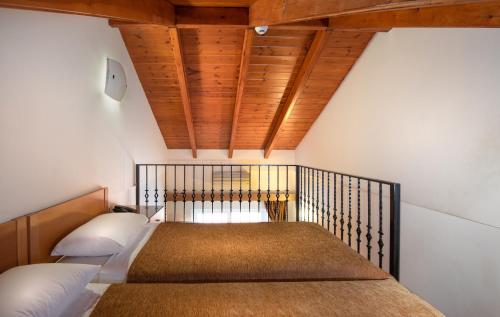 a bedroom with a bed and a wooden ceiling at Sunday Hotel in Ialyssos