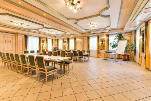 une salle de conférence avec une grande table et des chaises dans l'établissement Flair Hotel Vier Jahreszeiten, à Bad Urach