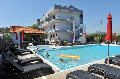 a pool with chairs and a person in the water at Maritime in Kremasti