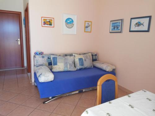 a room with a blue couch with pillows on it at Apartmani Marija in Primošten