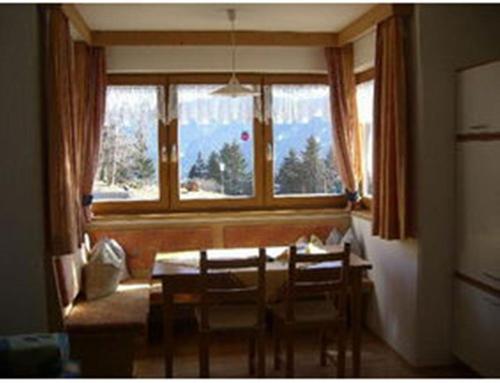 a dining room with a table and chairs and a window at Apart Ramona in Serfaus