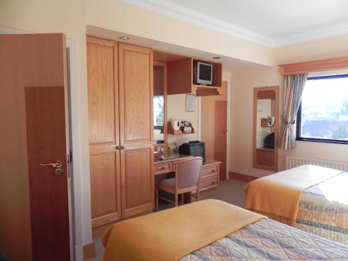 a hotel room with a bedroom with a desk and a bed at Shelmalier House in Athlone