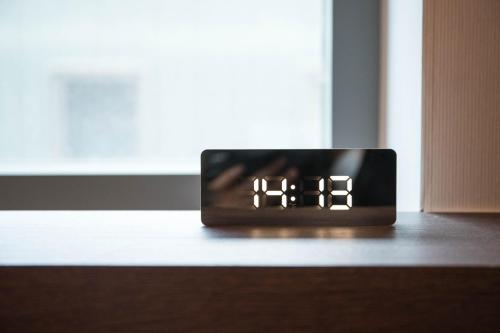 a alarm clock sitting on a table in front of a window at Calistar Hotel in Seoul