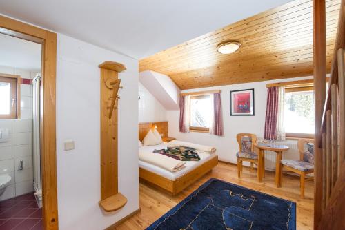 a bedroom with a bed and a bathroom at Sattleggers Alpenhof & Feriensternwarte in Berg im Drautal