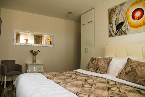 a bedroom with a bed and a chair and a mirror at Villa Grandioza in Seline