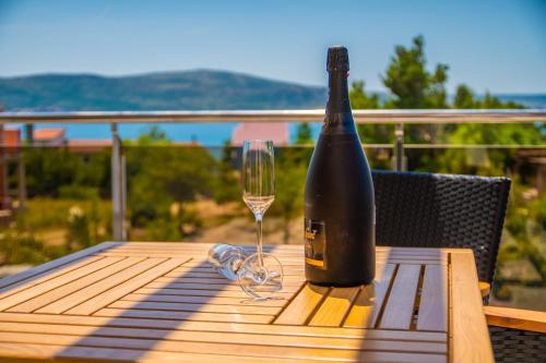 a bottle of wine sitting on a table with a glass at Villa Grandioza in Seline
