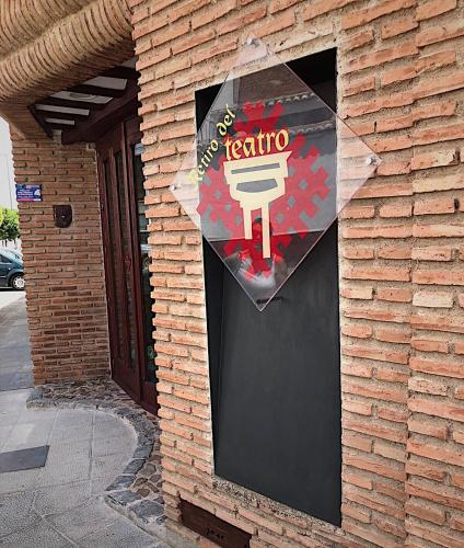 a sign for a restaurant on the side of a brick building at Retiro del Teatro Almagro in Almagro