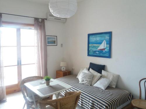 a room with a bed with a table and a sailboat on the wall at Studio in Poros in Poros
