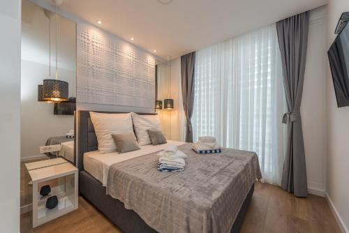 ein Schlafzimmer mit einem Bett und einem großen Fenster in der Unterkunft Gallery Rooms in Zadar
