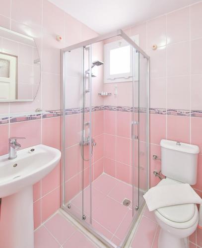 a pink bathroom with a toilet and a sink at Kiraz Butik Hotel in Alaçatı