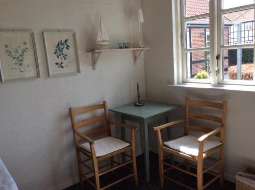 une chambre avec deux chaises, une table et une fenêtre dans l'établissement Strandværelserne, à Ebeltoft