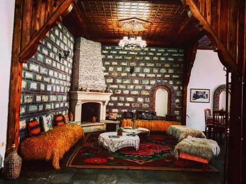 a living room with a fireplace and a stone wall at Hotel Berati in Berat