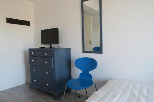 a bedroom with a blue chair and a dresser at Bed & Breakfast du Nord in Vejby