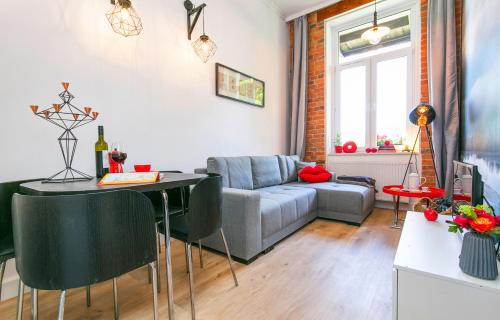 - un salon avec un canapé et une table dans l'établissement BERG Apartament RED obok Starego Miasta, à Gdańsk