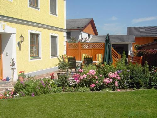 a backyard with a garden with flowers and a house at Familienbauernhof Strassbauer in Steinakirchen am Forst
