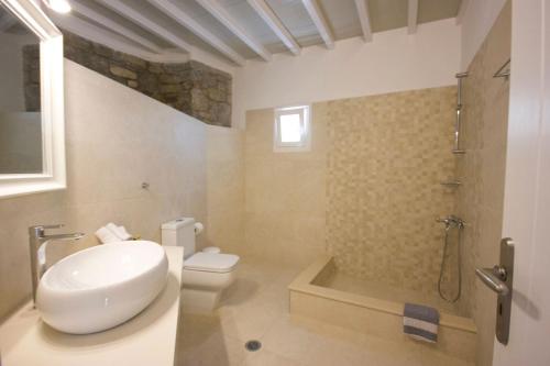 a bathroom with a toilet and a shower and a sink at Anixi Hotel in Ornos