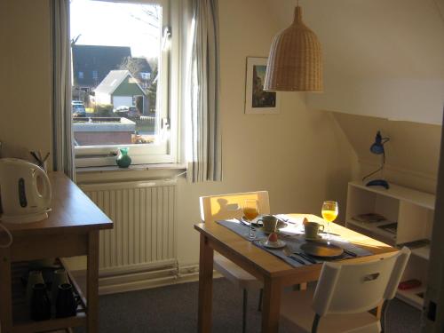 einen Tisch und Stühle mit einem Tisch und einem Fenster in der Unterkunft B&B De Esdoorn in Norg