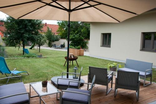 a patio with chairs and tables and an umbrella at Sabines Apartments Ferienwohnungen in Frauenkirchen